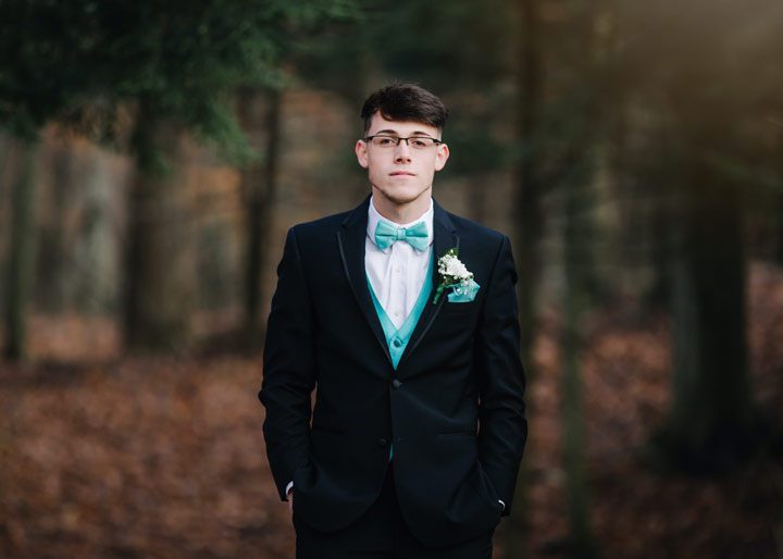 young man dressed in suit for senior prom