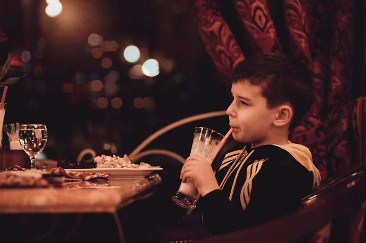 boy drinking milkshake at restaurant