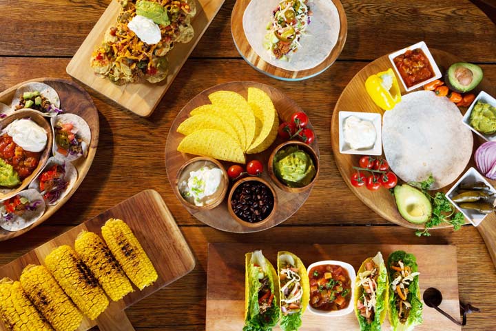 tacos and taco fixings set out on a table - food