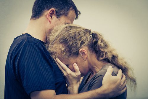 man consoling upset woman