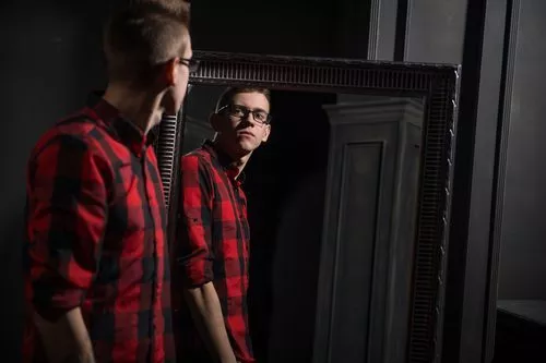 young man looking in mirror