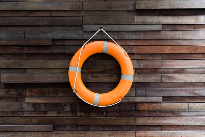 image of life saver ring hanging on wooden wall