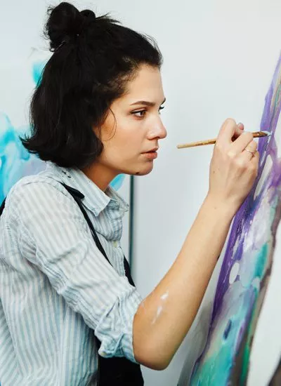 pretty young brunette woman painting - art therapy - post-traumatic stress disorder