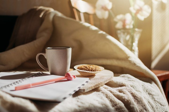 coffee, muffin, and journal sitting on bed in morning - establishing routines