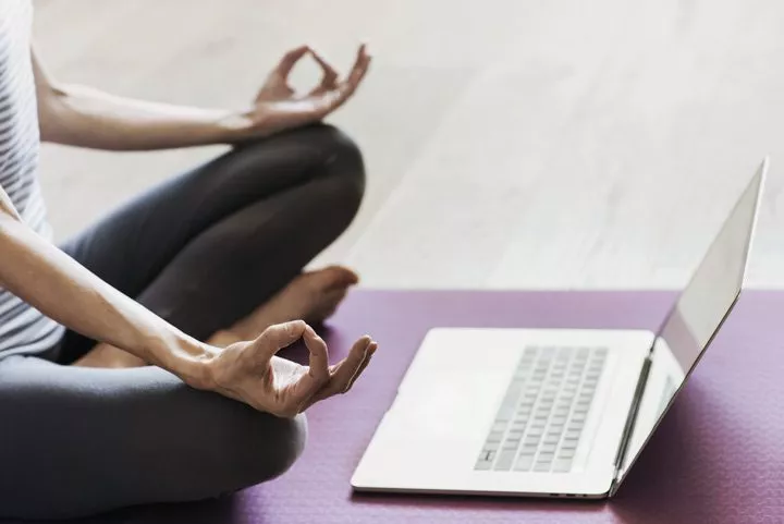 woman doing yoga at home in front of laptop - yoga practice