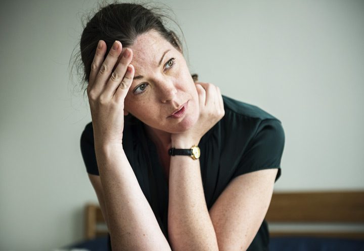 woman looking stressed, with hand on head, thinking - willpower