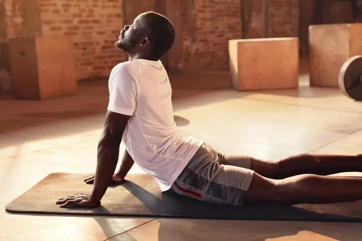 young Black man doing yoga on mat - thoughts and emotions