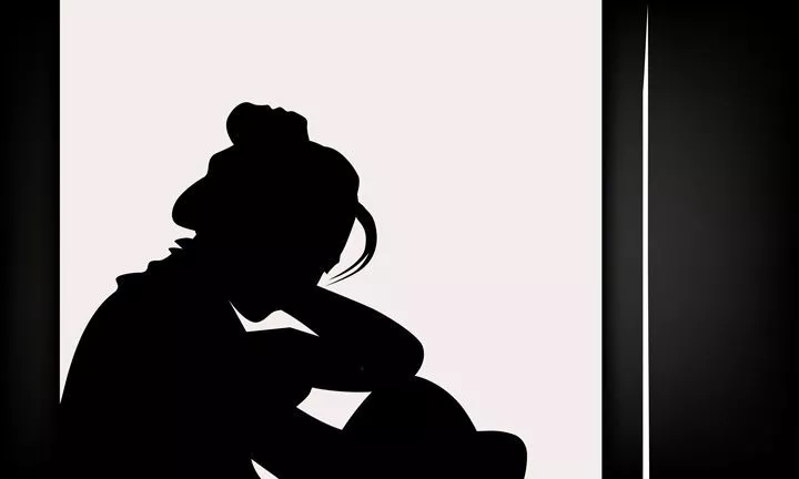black and white illustration of woman's silhouette in window, sad and alone - complicated grief