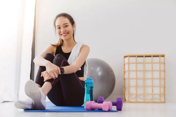 pretty young woman in workout clothes smiling at the camera - brain health