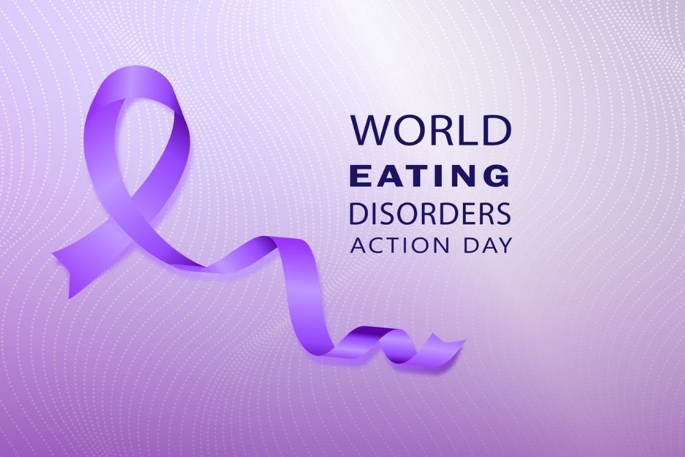 Purple awareness ribbon and the words 'World Eating Disorders Action Day' on a light purple dotted background.